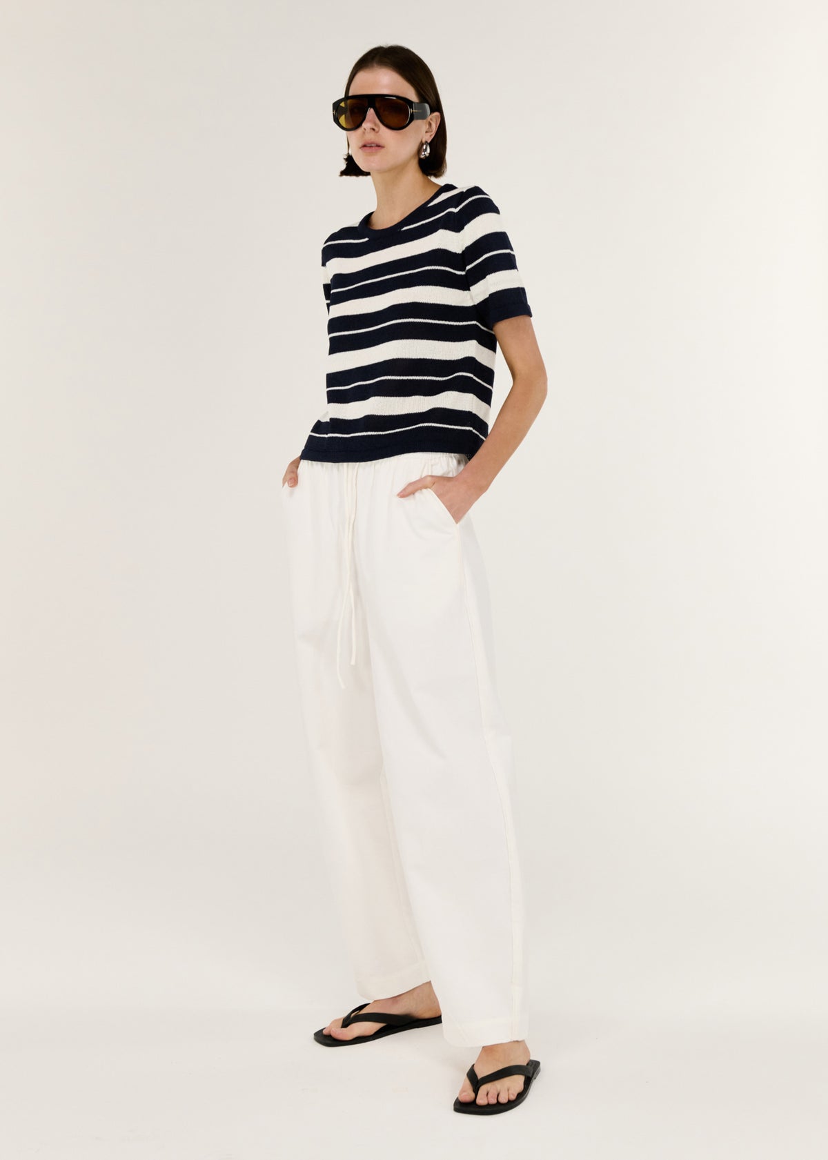 Model wearing Striped Crew Neck Knit Tee with a timeless stripe design and a soft, lightweight knit feel.