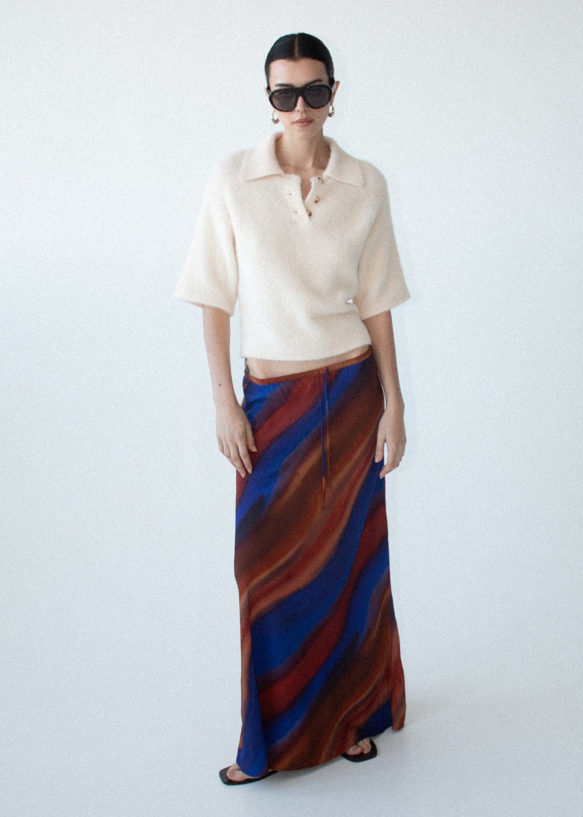 Model wearing Sunset Ombre Print Bias Maxi Skirt with a semi-sheer finish and a pull-on style.