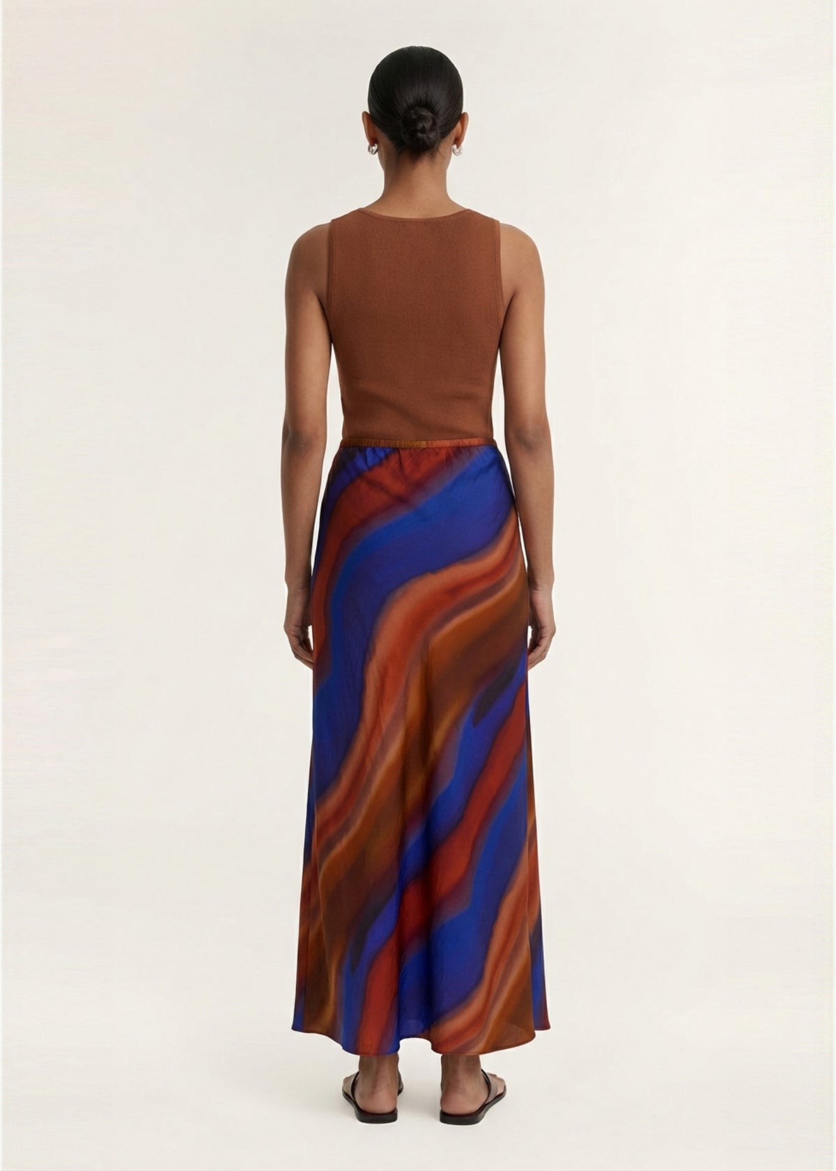 Model wearing Sunset Ombre Print Bias Maxi Skirt, showing a lightweight sheer fabrication and an exclusive abstract ombre print.