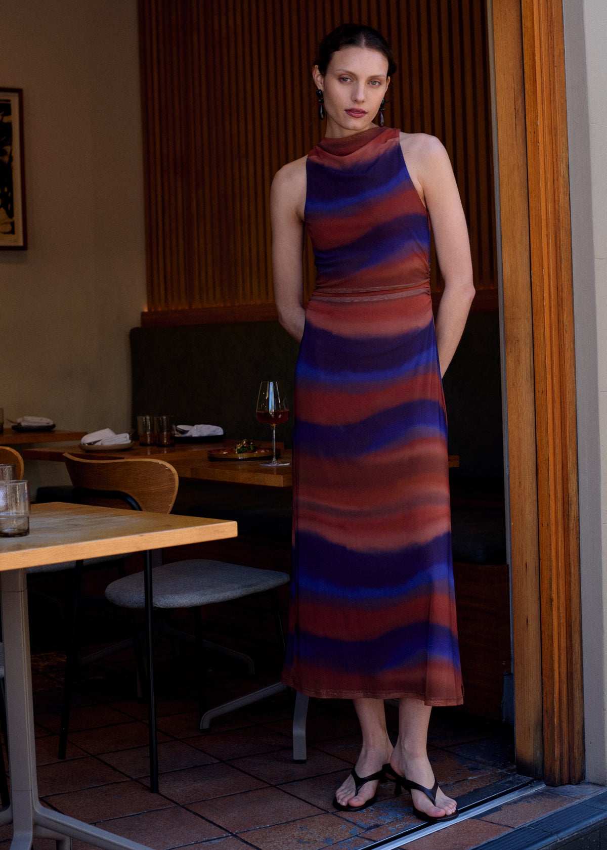 Model wearing Sunset Ombre Print Sleeveless Mesh Midi Dress with a sleeveless cut and a midi length.