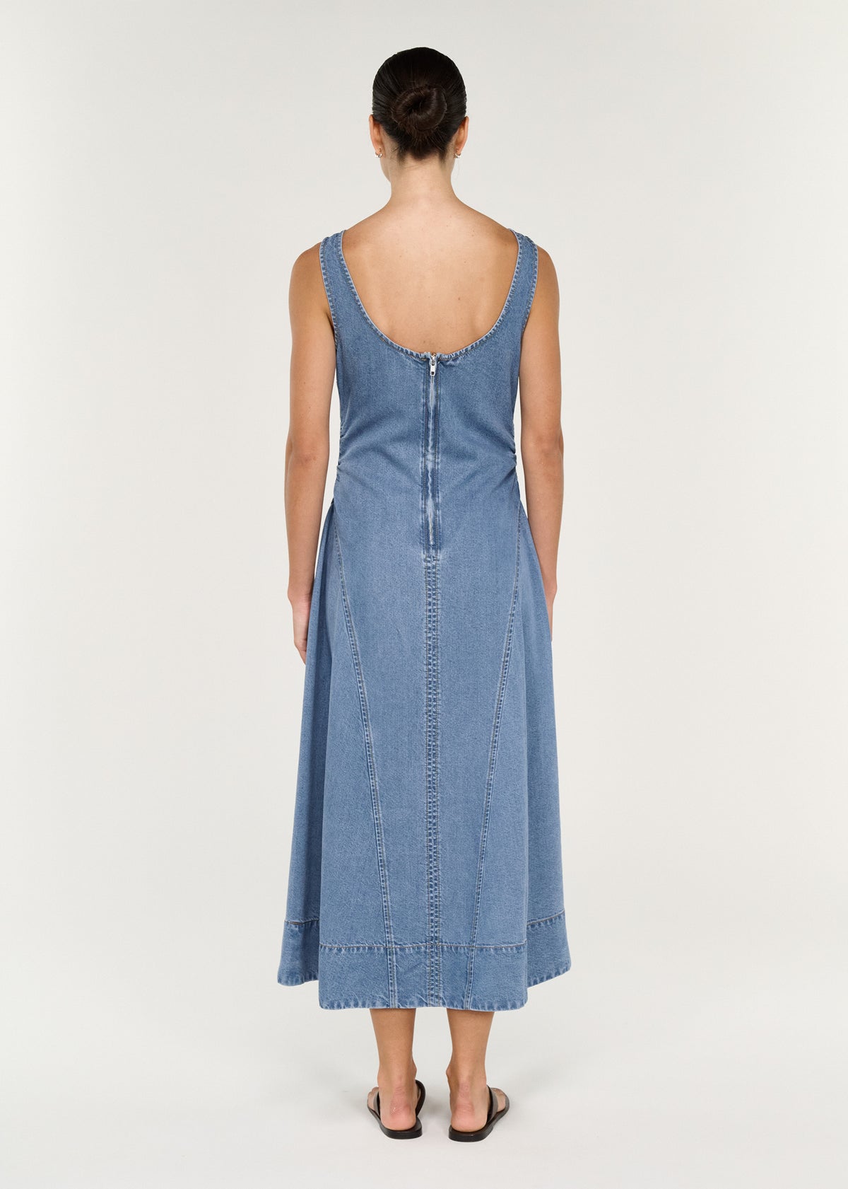 Back view of Chambray Denim Sleeveless Midi Dress highlighting fitted bodice and flowing A-line skirt.
