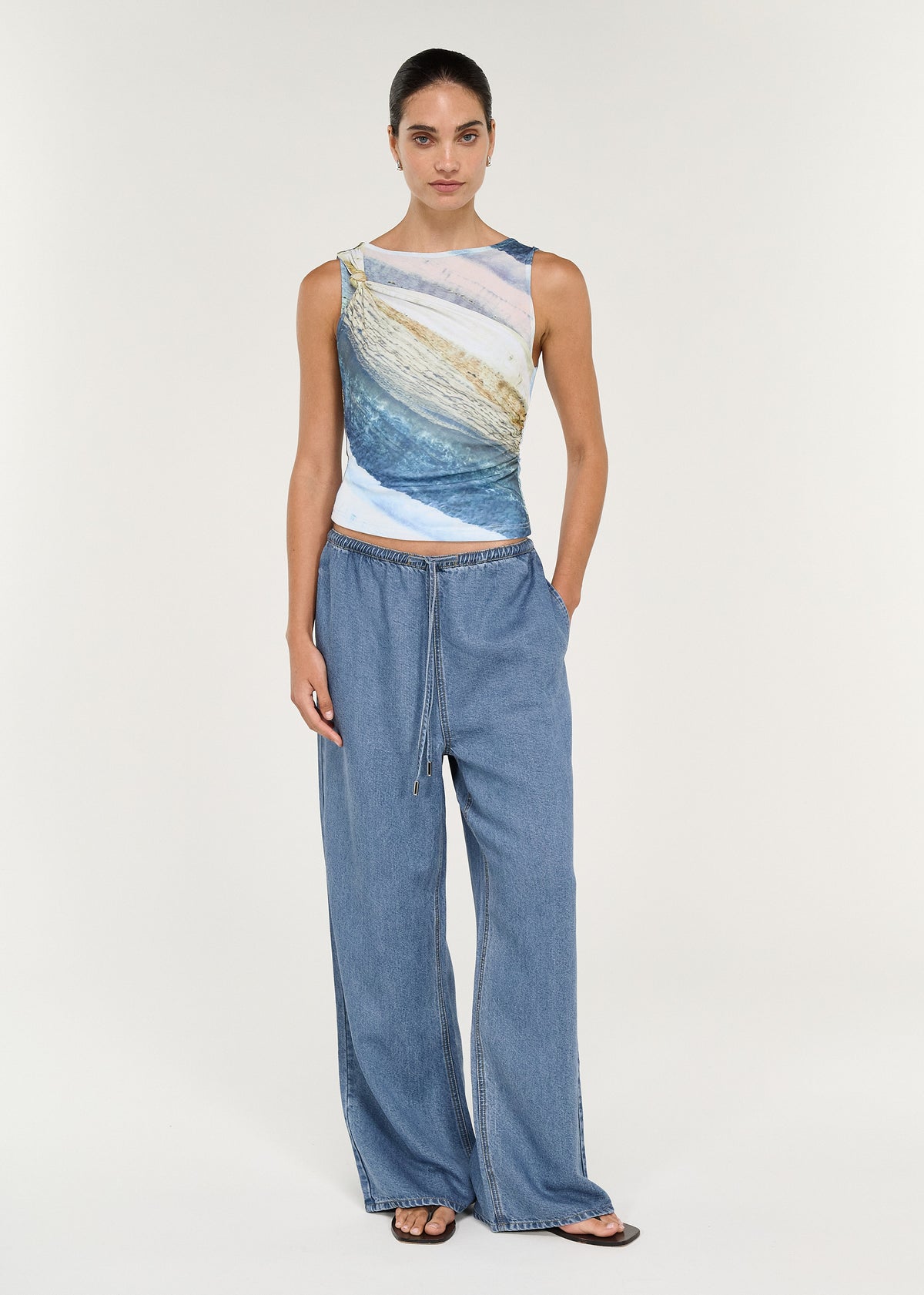 Model wearing Chambray Denim Relaxed Drawstring Pant with a stylish top, showcasing a relaxed wide-leg fit in washed blue chambray.