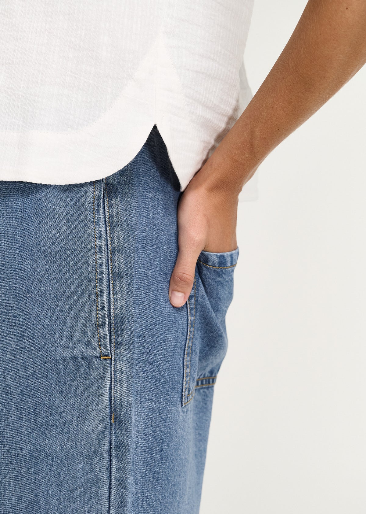 Close-up of a hand in the side pocket of the Chambray Denim Relaxed Drawstring Pant.