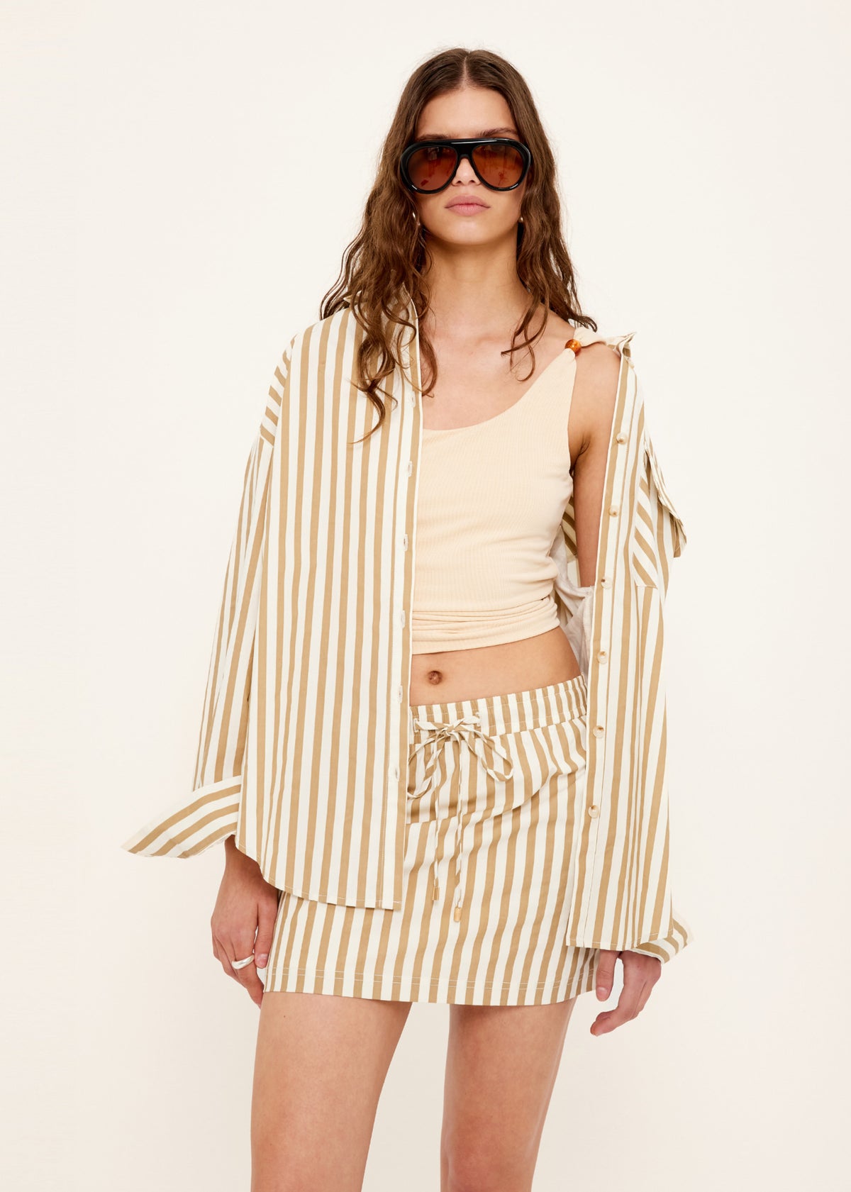 Model wearing Tan Stretch Tank with Bead Detail with a soft ribbed knit texture and a scoop neckline.
