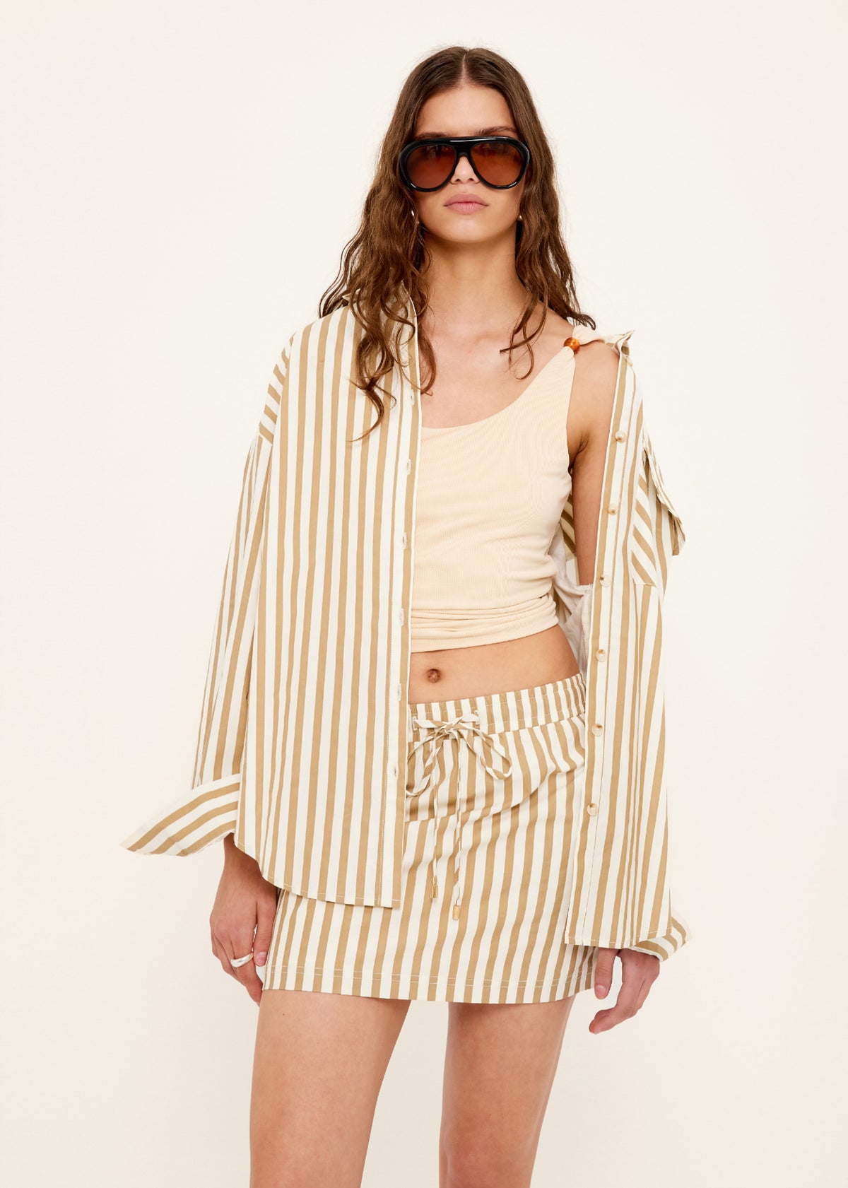 Model wearing Tan Stretch Tank with Bead Detail with a fitted silhouette and a cropped length.
