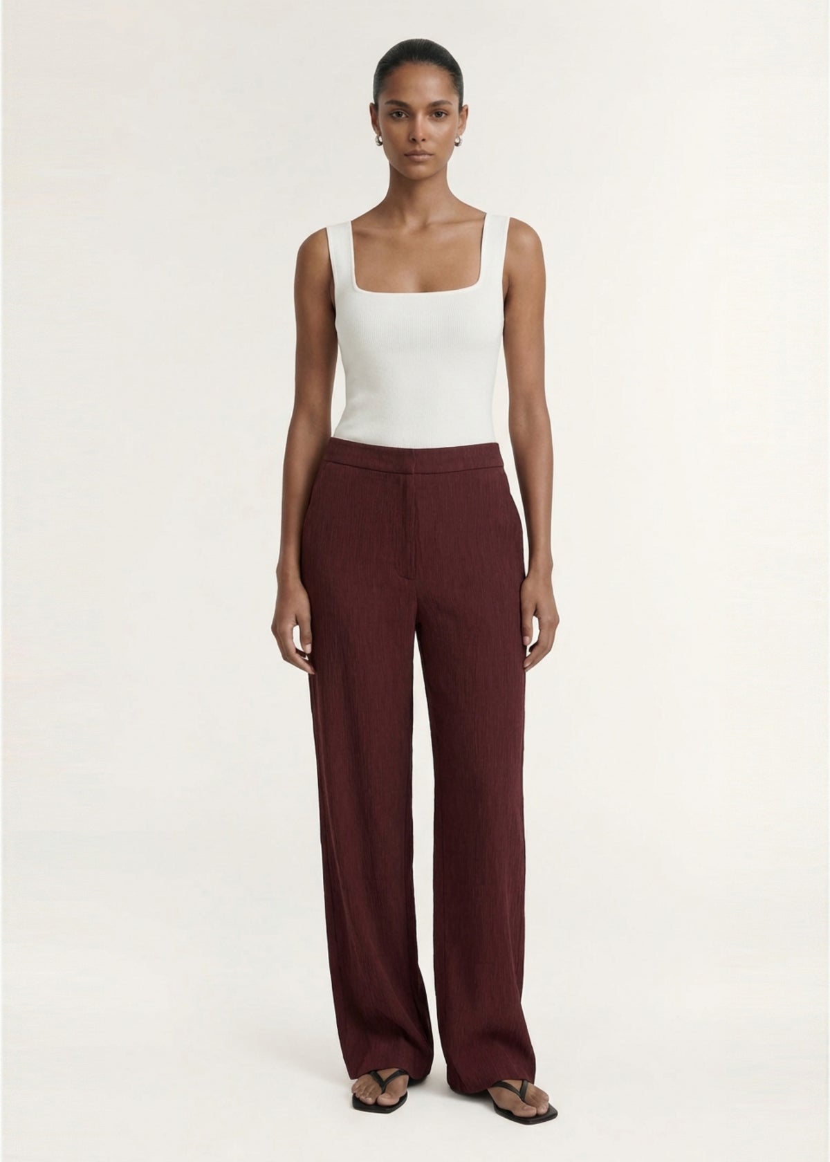 Model wearing Textured Burgundy Relaxed Fit Pant with a textured woven fabrication and a relaxed wide leg silhouette.