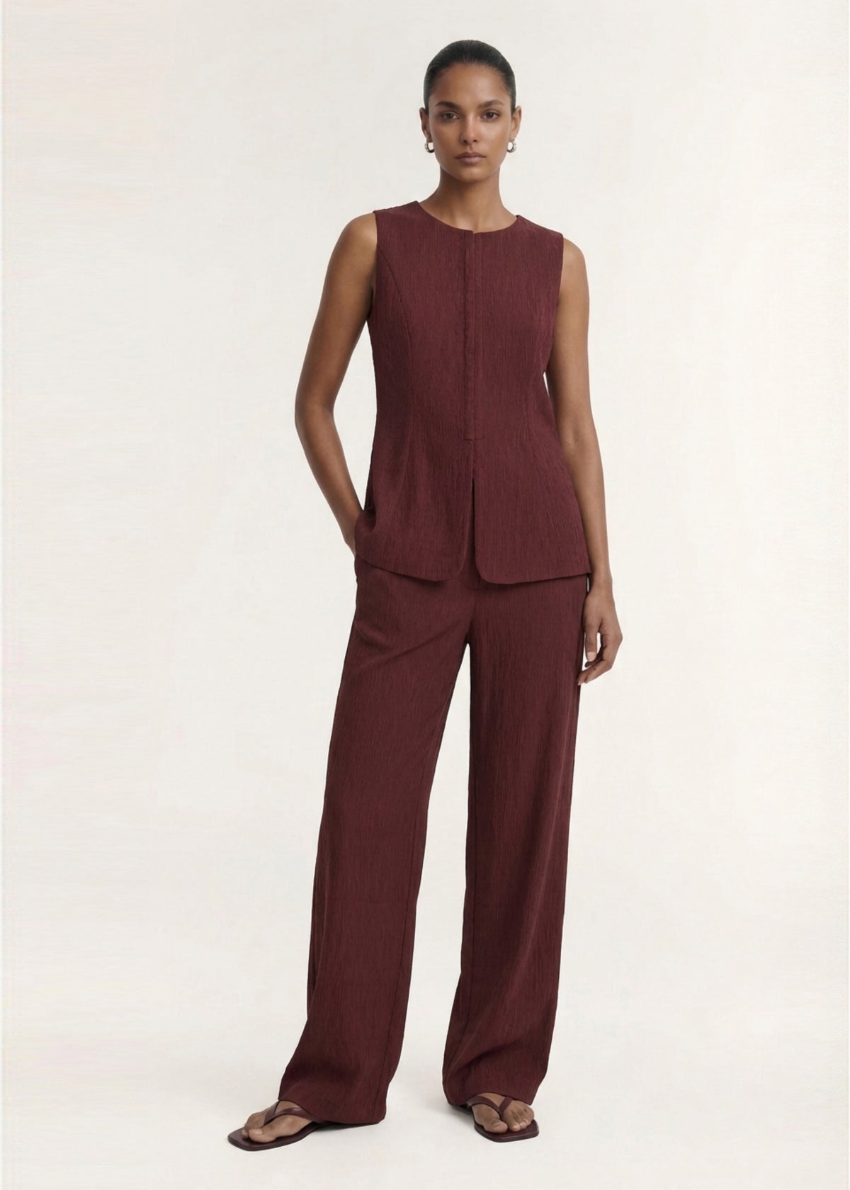 Model wearing Textured Burgundy Relaxed Fit Pant with a relaxed wide leg silhouette and a textured woven fabrication.