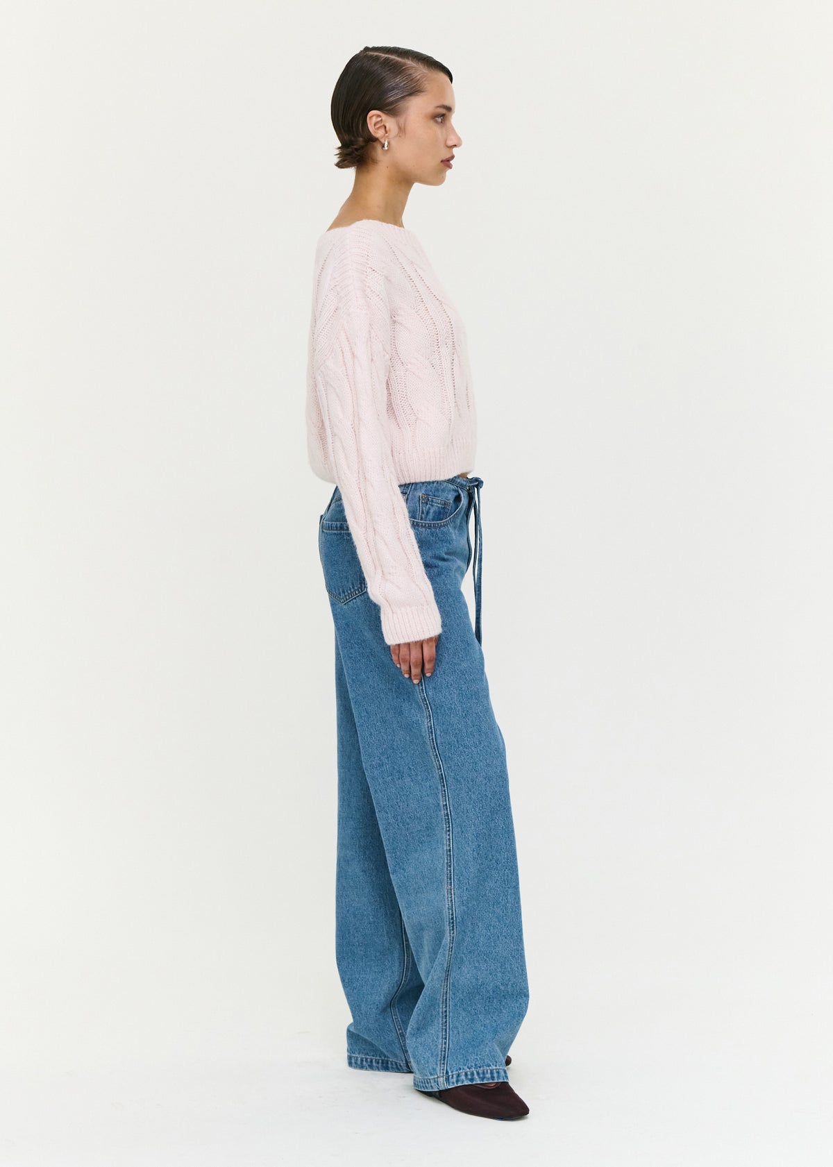 Side profile of the Tie Waist Detail Mid Rise Jeans with a curved seam detailing and an adjustable waist tie detail.