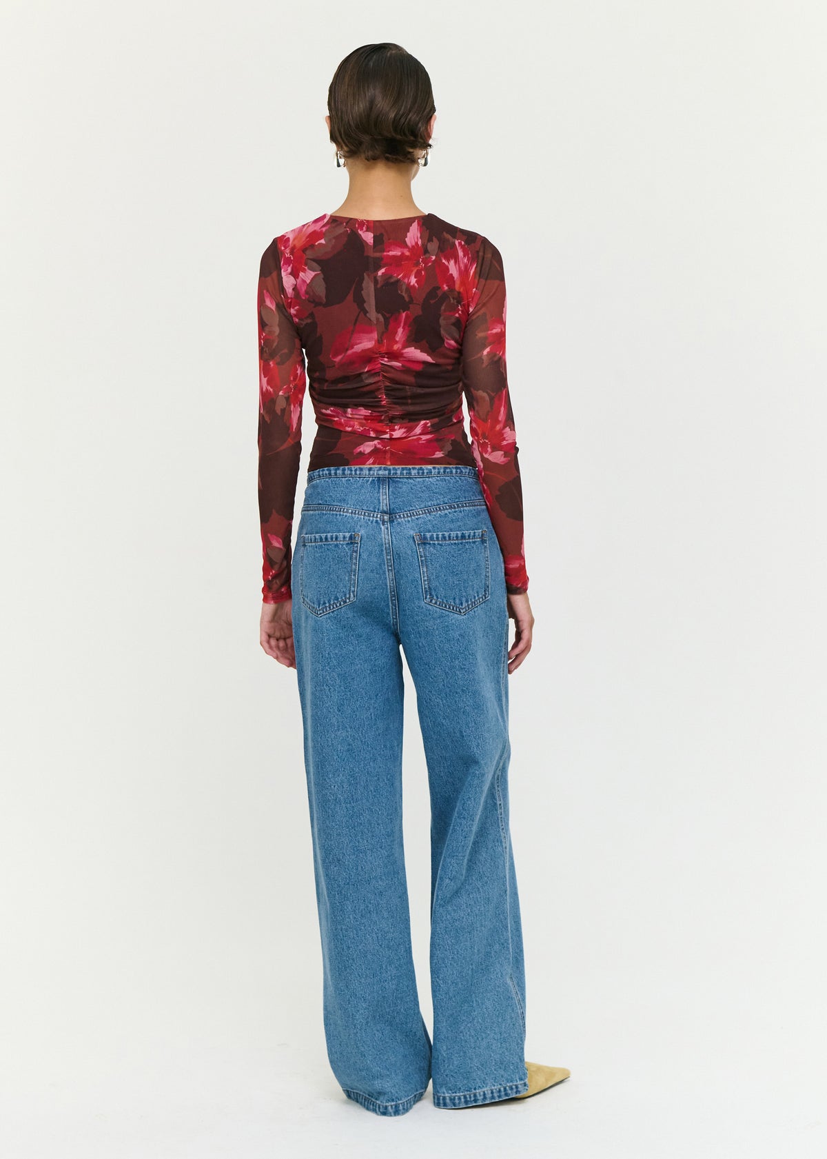 Back view of the Tie Waist Detail Mid Rise Jeans with a zip and button front closure and an adjustable waist tie detail.
