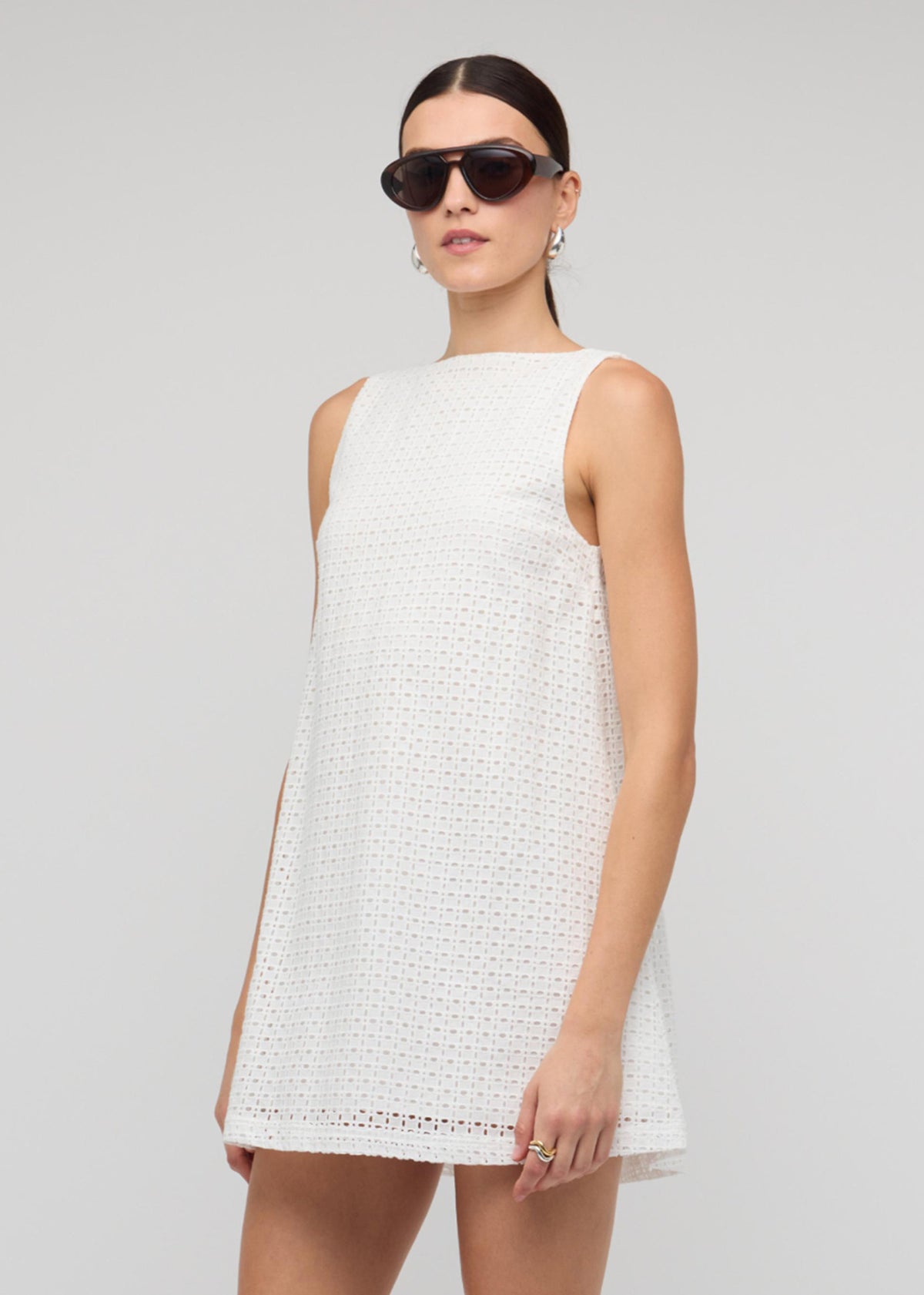 Model wearing White Broderie Mini Shift Dress with a deep V-back detail and a fully lined.