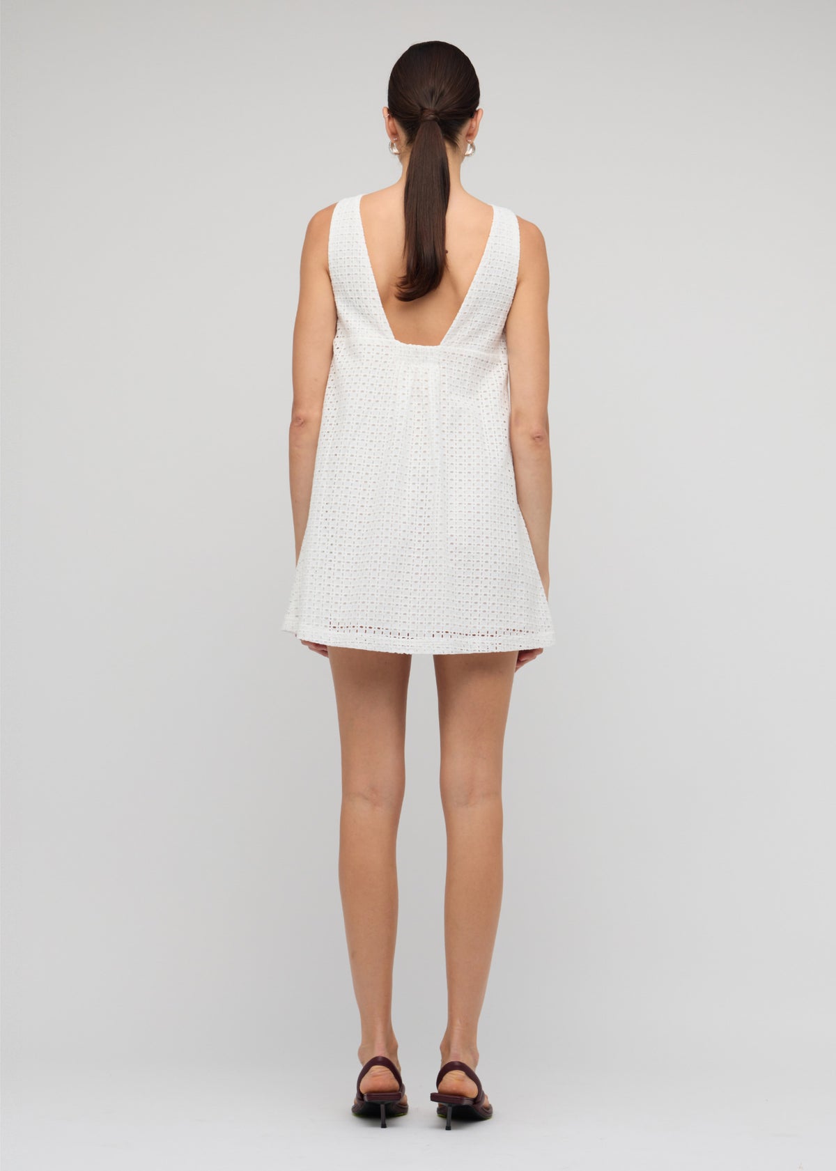 Back view of the White Broderie Mini Shift Dress, showing a deep V-back detail and a crisp white broderie fabric.