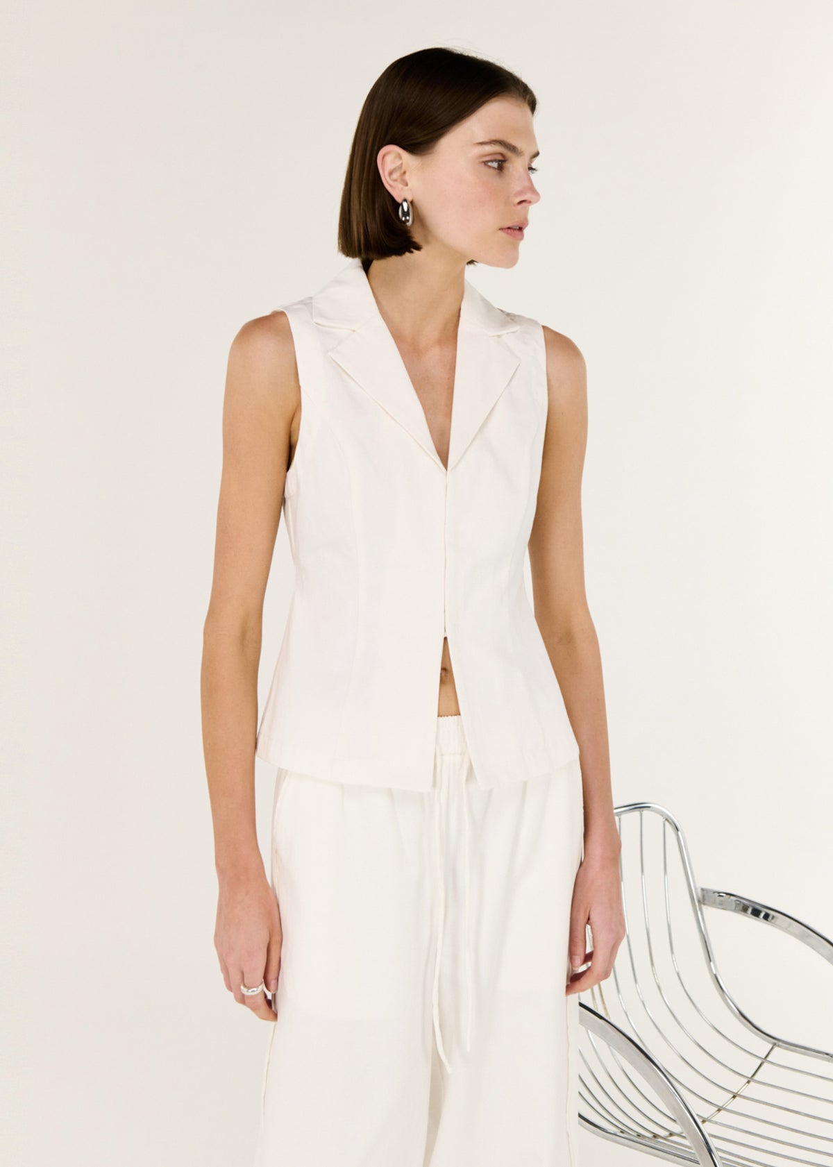 Close-up of the White Cotton Tailored Vest Top, showing a sleeveless cut and a structured lapel neckline.