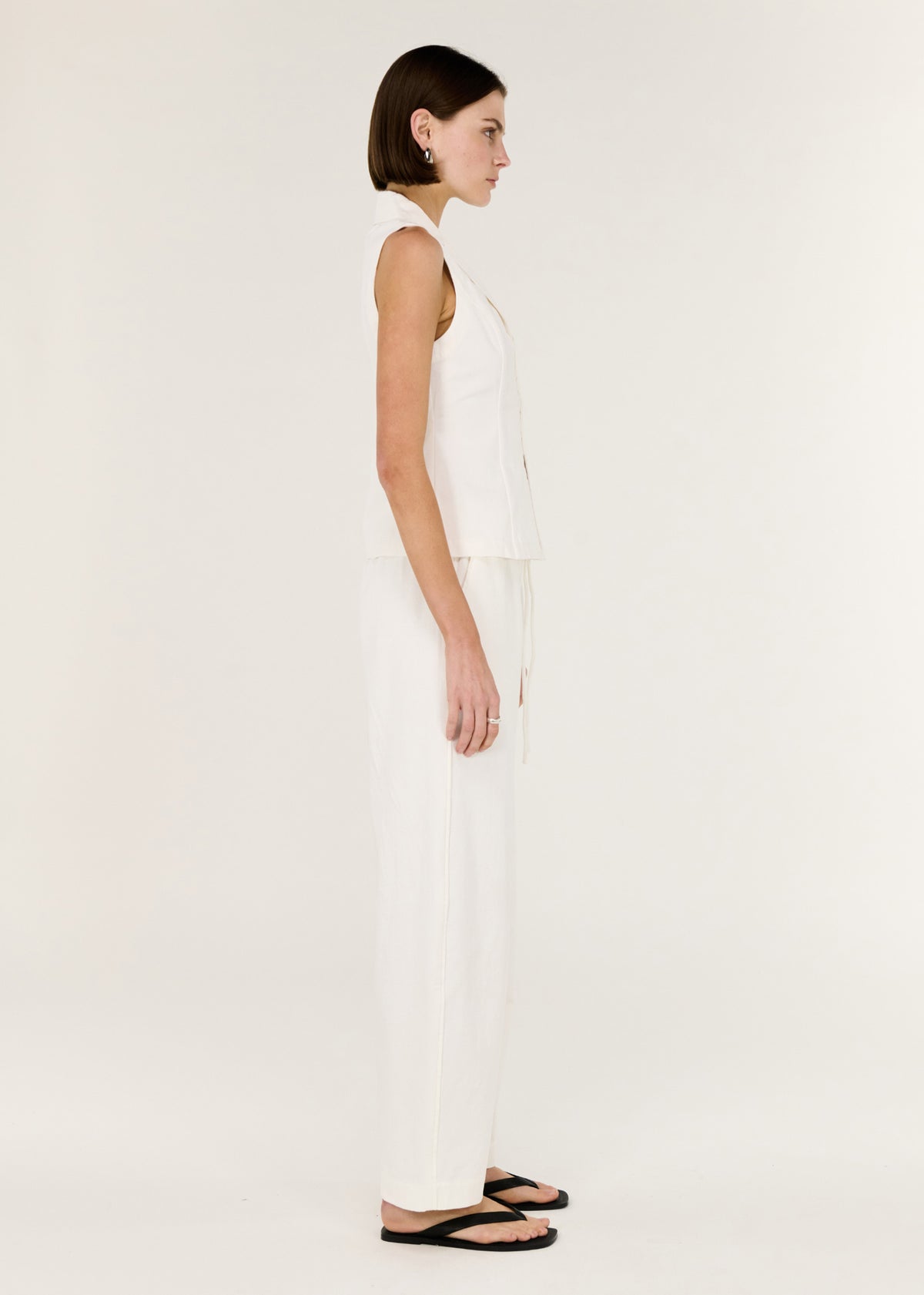 Side view of the White Cotton Tailored Vest Top, showing a soft yet structured silhouette and a designed.