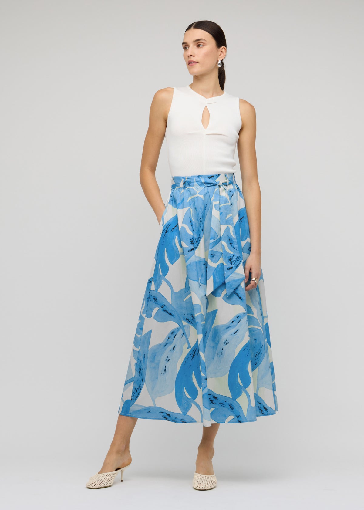 Model wearing White Cut-Out Sleeveless Knit Top with a fitted silhouette and a sleeveless cut.