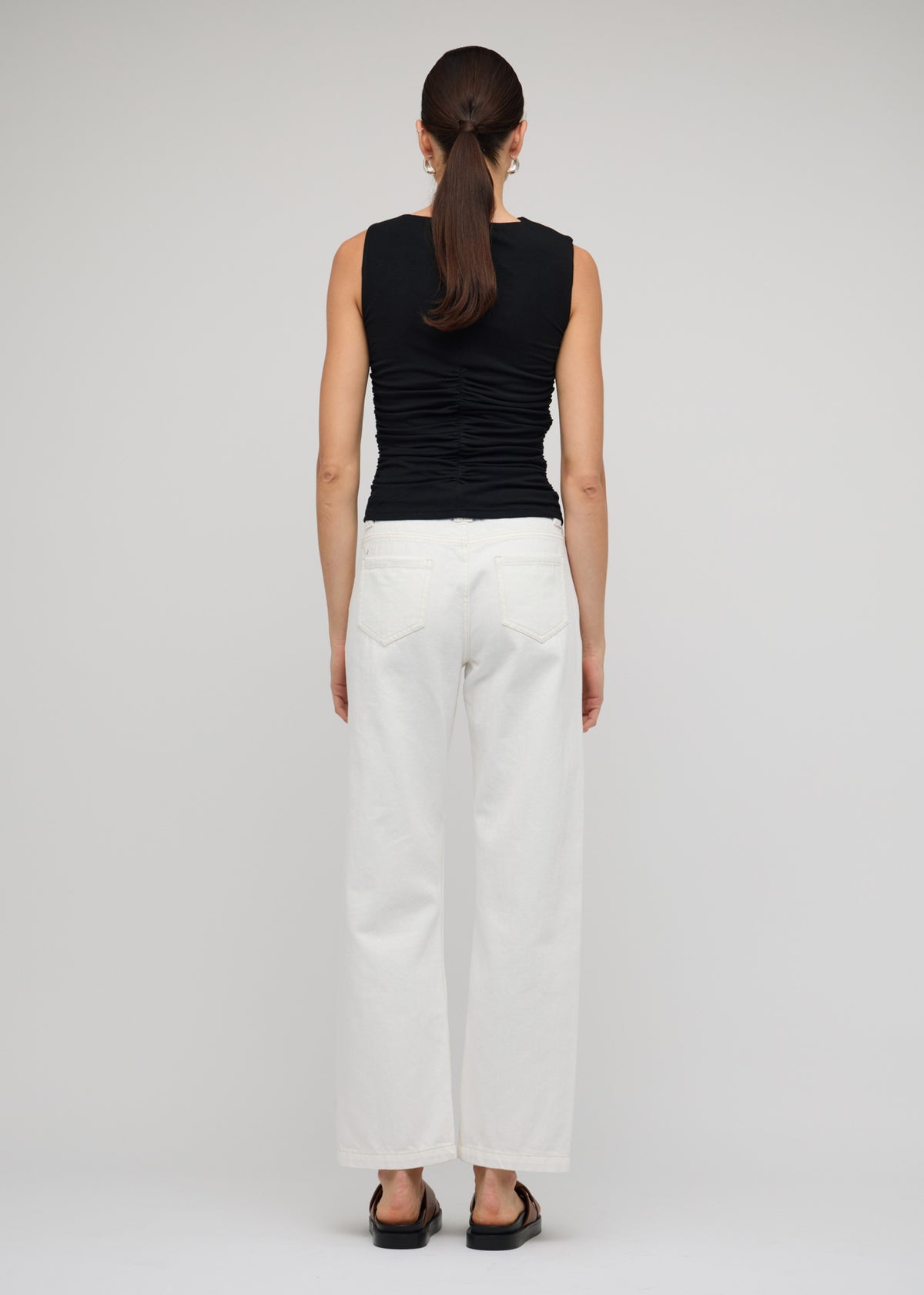Back view of the White Denim Mid-Rise Straight Jeans with a button and zip fly closure.