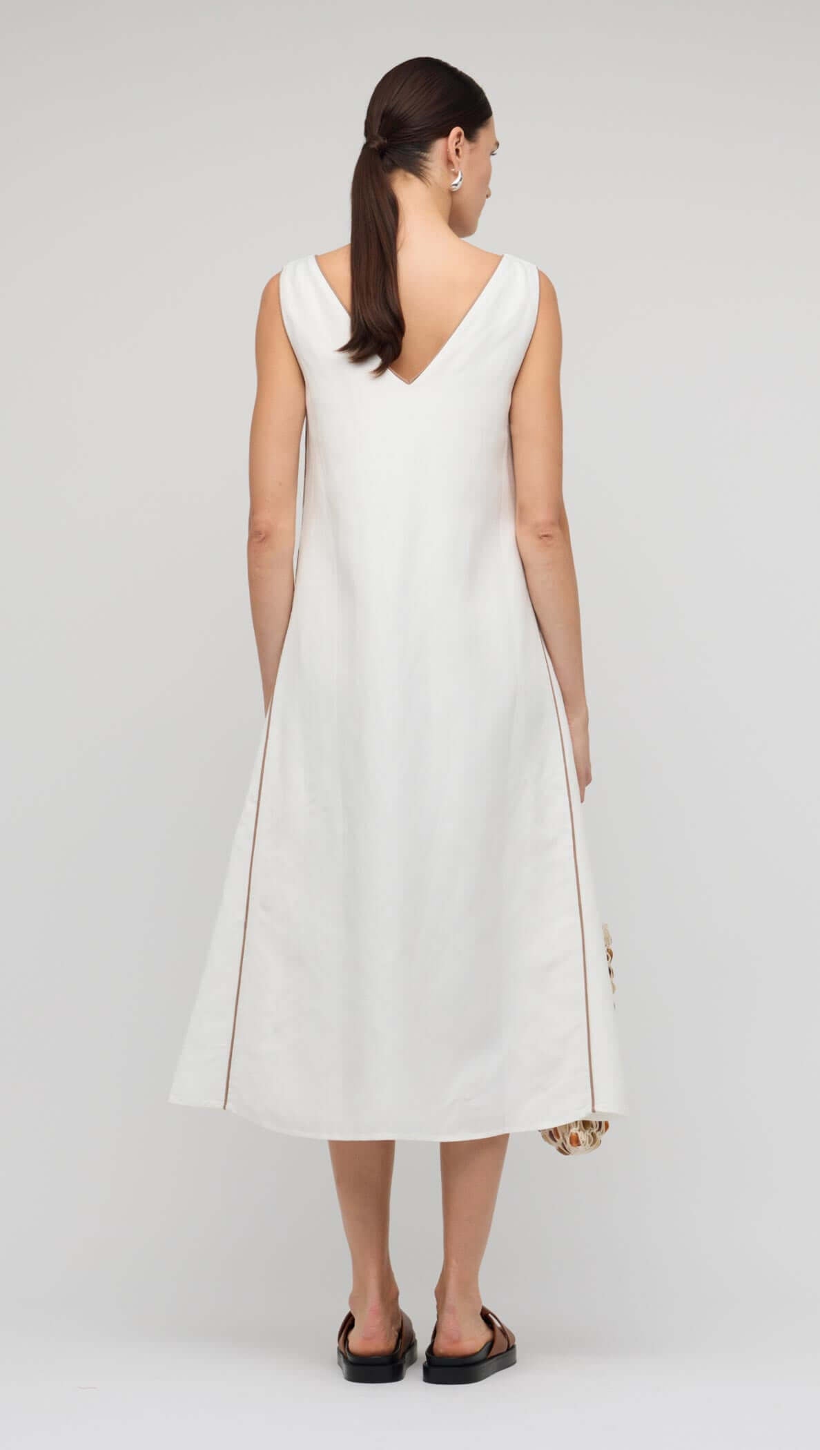 Back view of the White Godet Linen Midi Dress showcasing its elegant V-neckline and flared godet skirt.