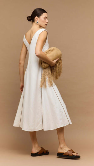 Model wearing White Godet Linen Midi Dress with a stylish clutch bag, showcasing the dress's elegant silhouette.