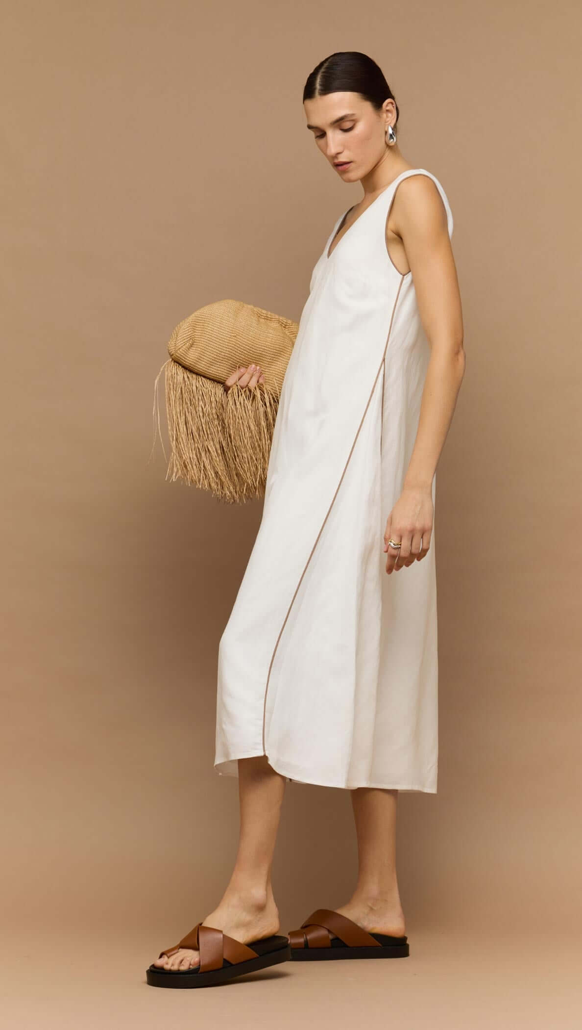 Model wearing a White Godet Linen Midi Dress by Staple the Label, featuring a V-neckline and wide straps.
