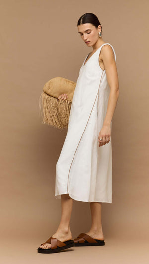 Model wearing a White Godet Linen Midi Dress by Staple the Label, featuring a V-neckline and wide straps.