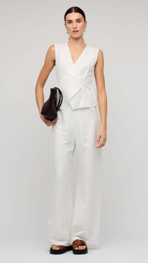 Model wearing White Linen Wide Leg Pants with a sleeveless top and a brown bag, showcasing a chic and relaxed look.