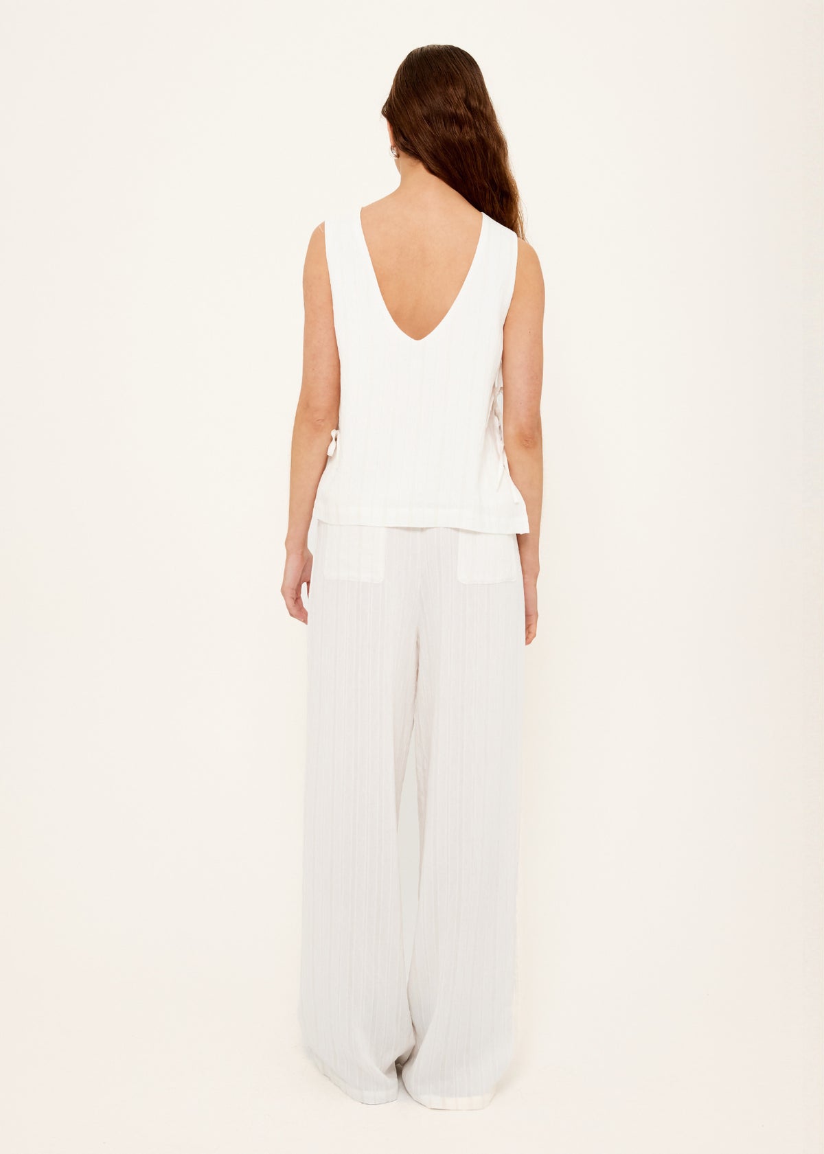 Back view of the White Tie-Side Top with a deep V-back neckline and a functional side tie detailing.