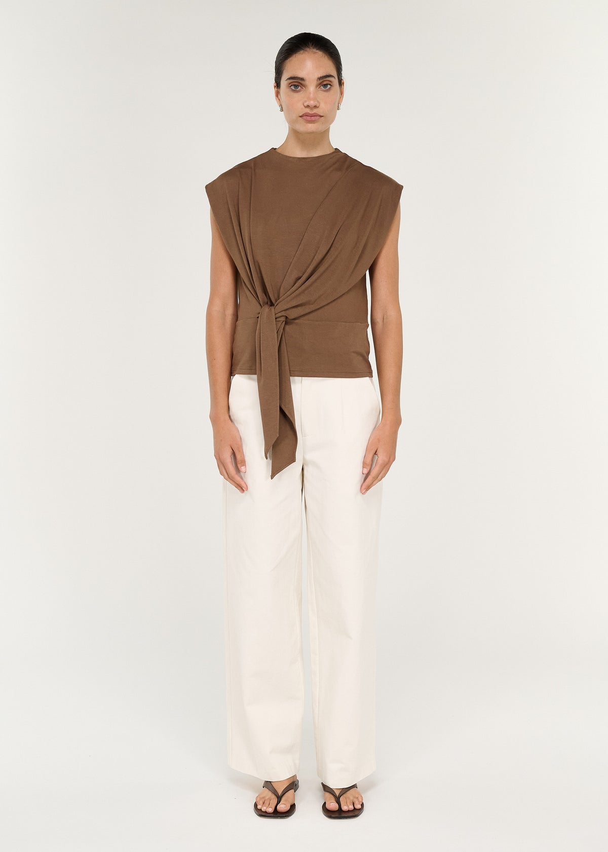 Model wearing a Draped Cotton Jersey Top in Mocha with tie detail, styled with white trousers.