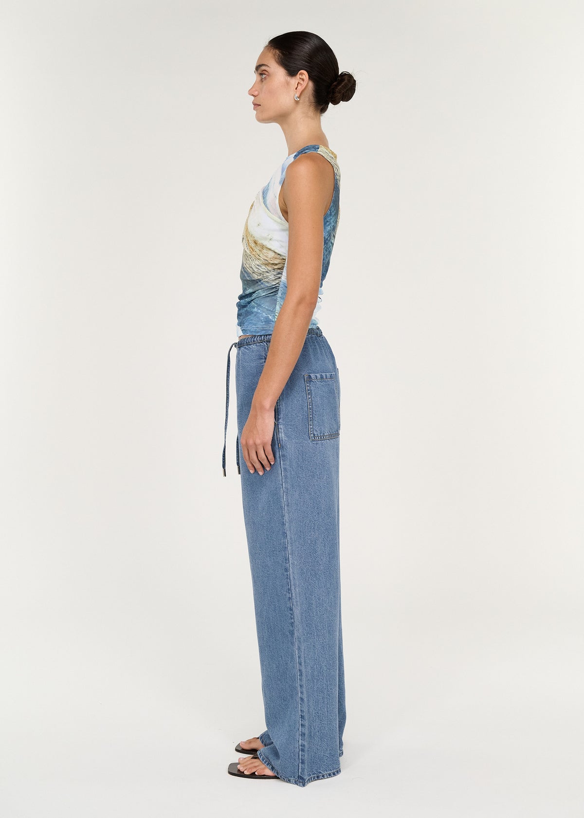 Sleeveless Mesh Twist Top in Ocean Tide styled with relaxed denim, showcasing a side view of the soft stretch mesh and design.