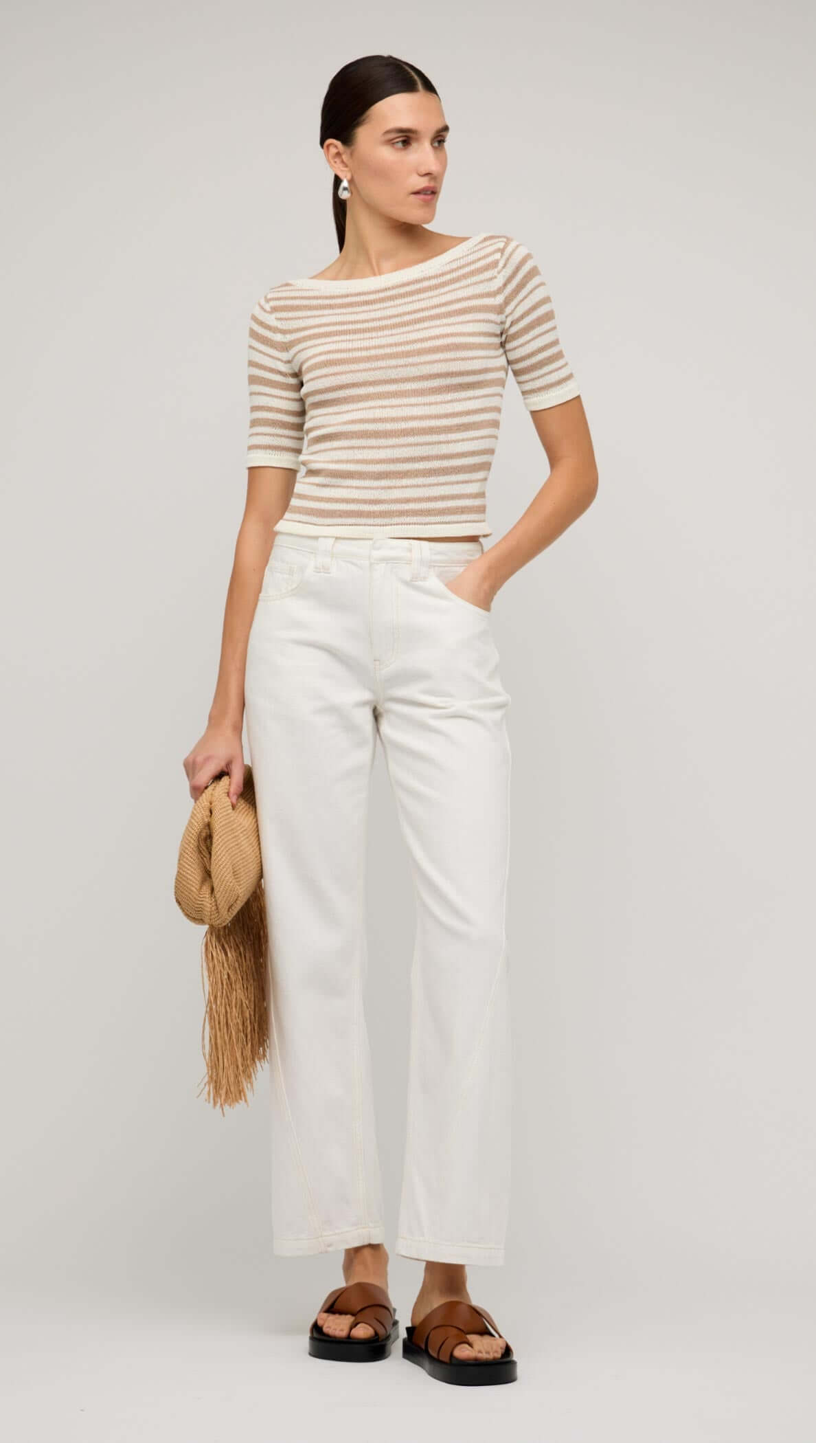 Model wearing white denim mid-rise straight jeans paired with a striped top, styled against a neutral background.