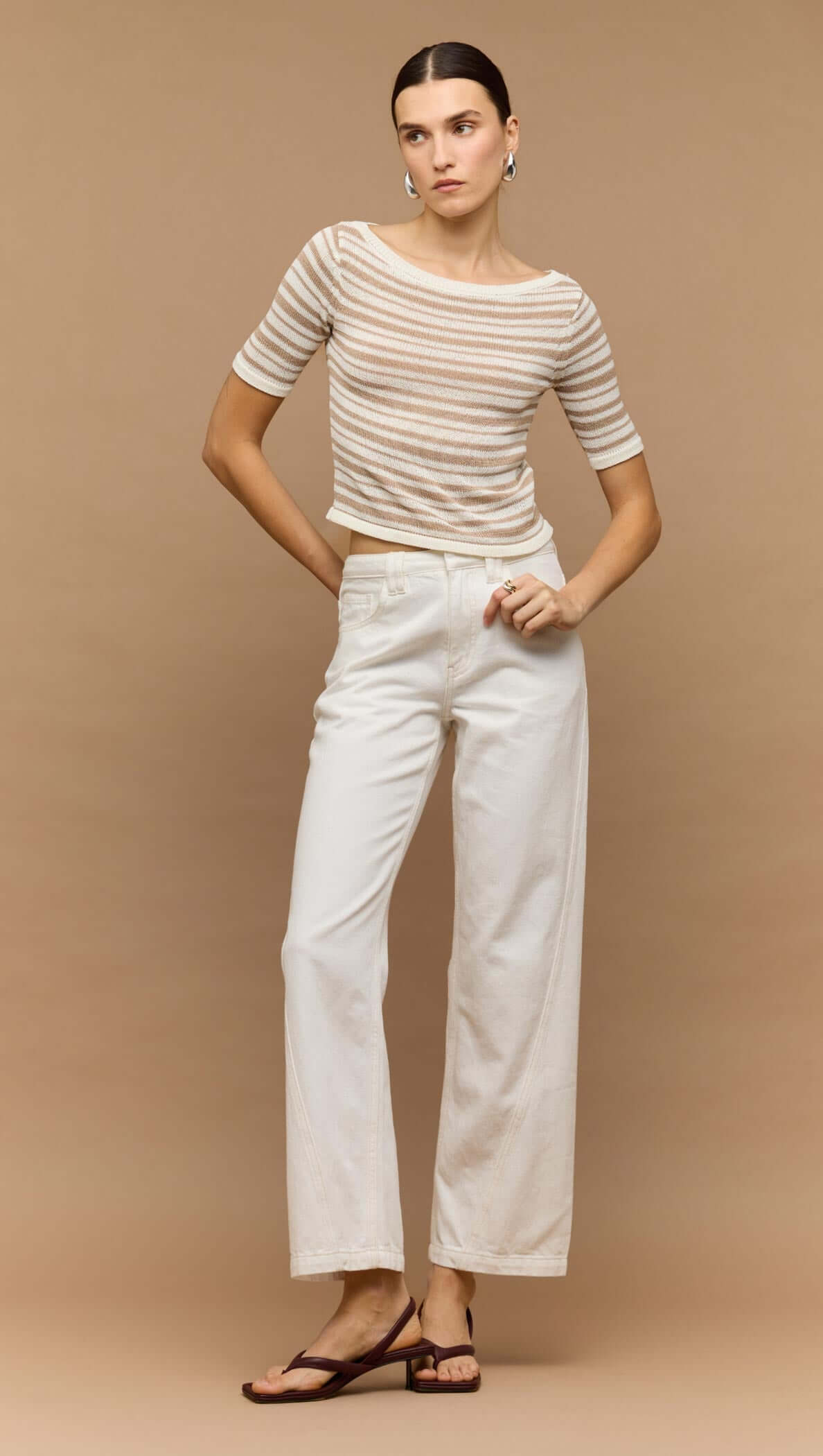 Model wearing white denim mid-rise straight jeans paired with a striped top, styled against a neutral background.